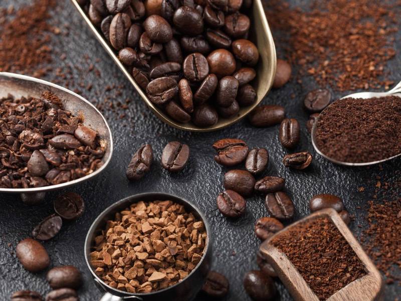 Verschiedene Löffel mit verschiedenen Arten von Kaffeepulver.