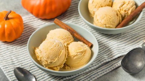 Zwei Schüsseln Kürbis-Eis, daneben mehrere Kürbisse.