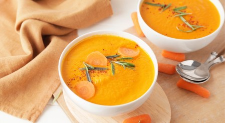 Zwei Schüsseln Möhrensuppe mit Curry.