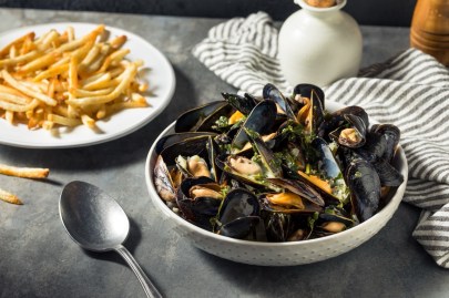 Eine Portion Moules frites, serviert mit Miesmuscheln und Pommes.