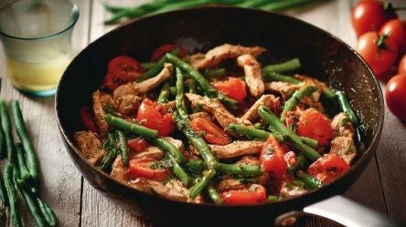 Putengeschnetzeltes mit Bohnen und Tomaten in einer Pfanne.