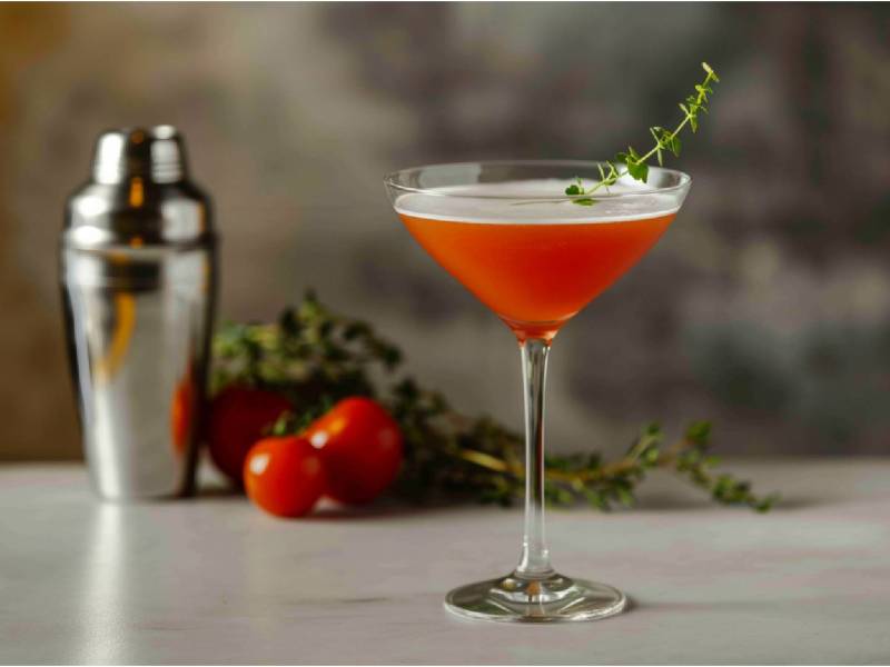 Ein Glas Tomatini mit einem Shaker daneben