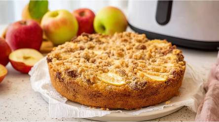 Ein gebackener Apfel-Streuselkuchen aus dem Airfryer, Äpfel und Airfryer im Hintergrund