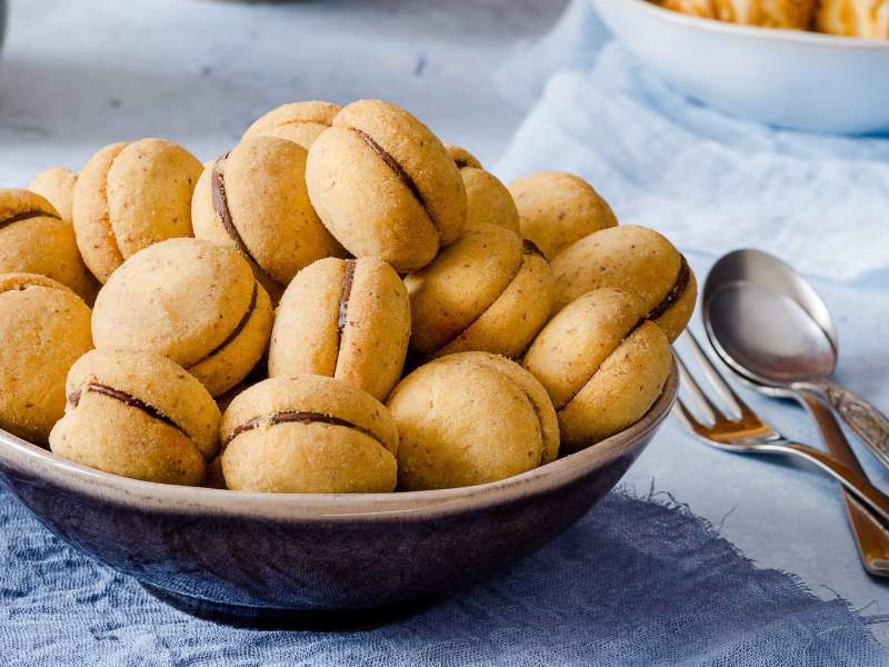 Baci di Dama in einer Schüssel, daneben Besteck.