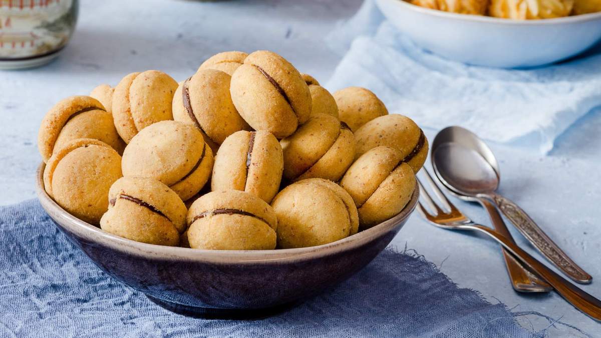 Baci di Dama in einer Schüssel, daneben Besteck.