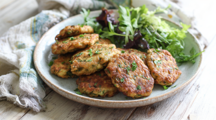 Bratlinge aus altem Brot auf einem grauen Teller. Hinten auf dem Teller liegt ein wenig Salat.