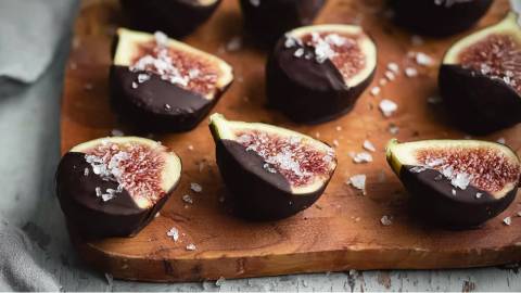 Holzbrett mit Feigen mit Schokolade und Meersalz