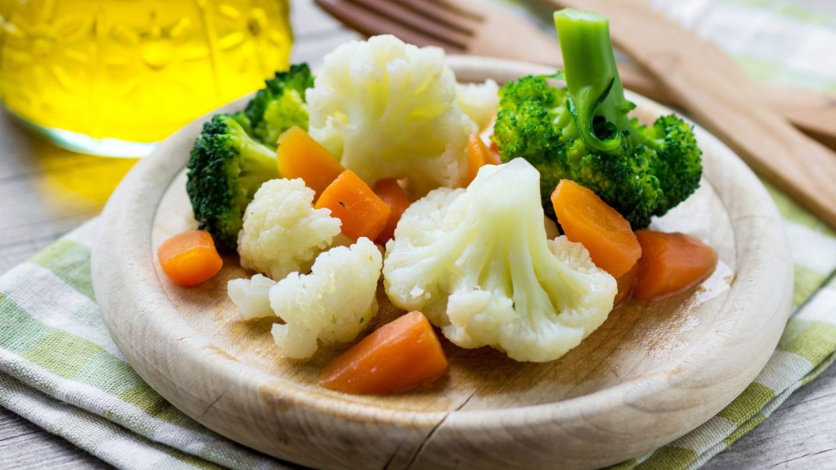 Gemüse dämpfen: Etwas gedämpftes Gemüse auf einem Holzbrett.