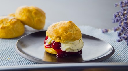 Ein glutenfreier Windbeutel auf einem dunklen Teller.