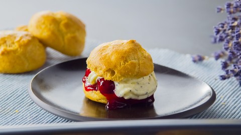 Ein glutenfreier Windbeutel auf einem dunklen Teller.