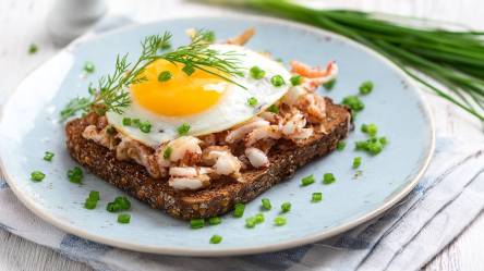 Teller mit einem Halligbrot mit Krabben und Spiegelei