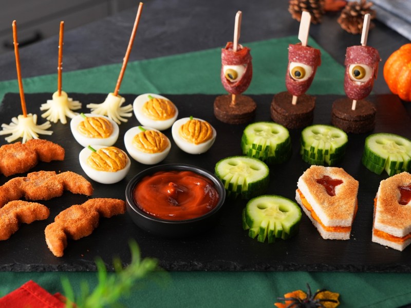 Verschiedenes Halloween-Fingerfood auf einem Schieferbrett.