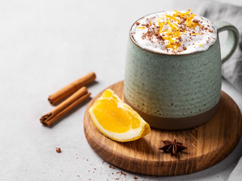 Eine Tasse heiße Schokolade mit Orange und Sahne.