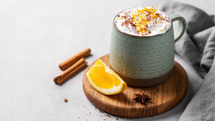 Eine Tasse heiße Schokolade mit Orange und Sahne.