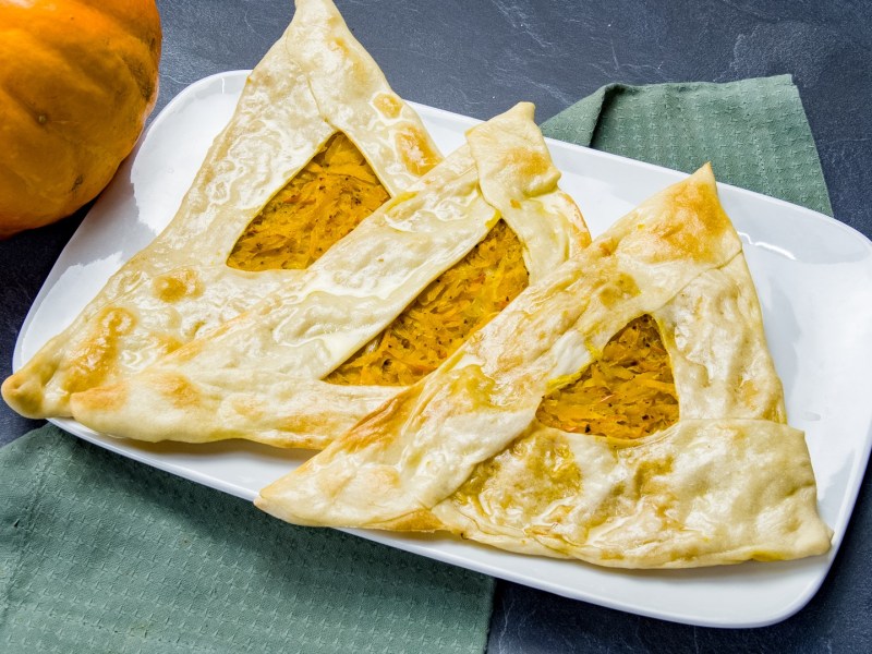 Ein Teller mit drei Kürbis-Bolani.