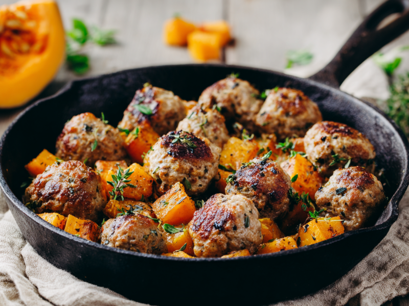 Eine gusseiserne Pfanne mit einer Kürbis-Hackbällchen-Pfanne darin.