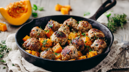 Eine gusseiserne Pfanne mit einer Kürbis-Hackbällchen-Pfanne darin.