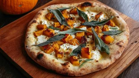 Eine Kürbis-Ricotta-Pizza auf einem Holtbrett