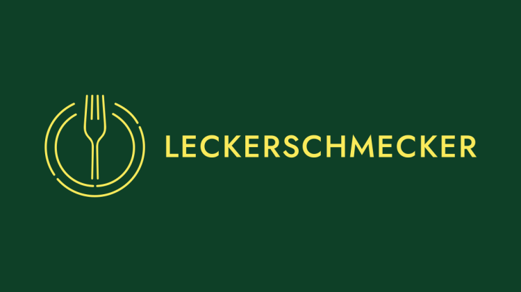 Zwei Maronenknödel mit Entenfüllung auf einem Teller mit Rotkohl. Einer der Knödel wurde aufgeschnitten, um die Füllung zu präsentieren.