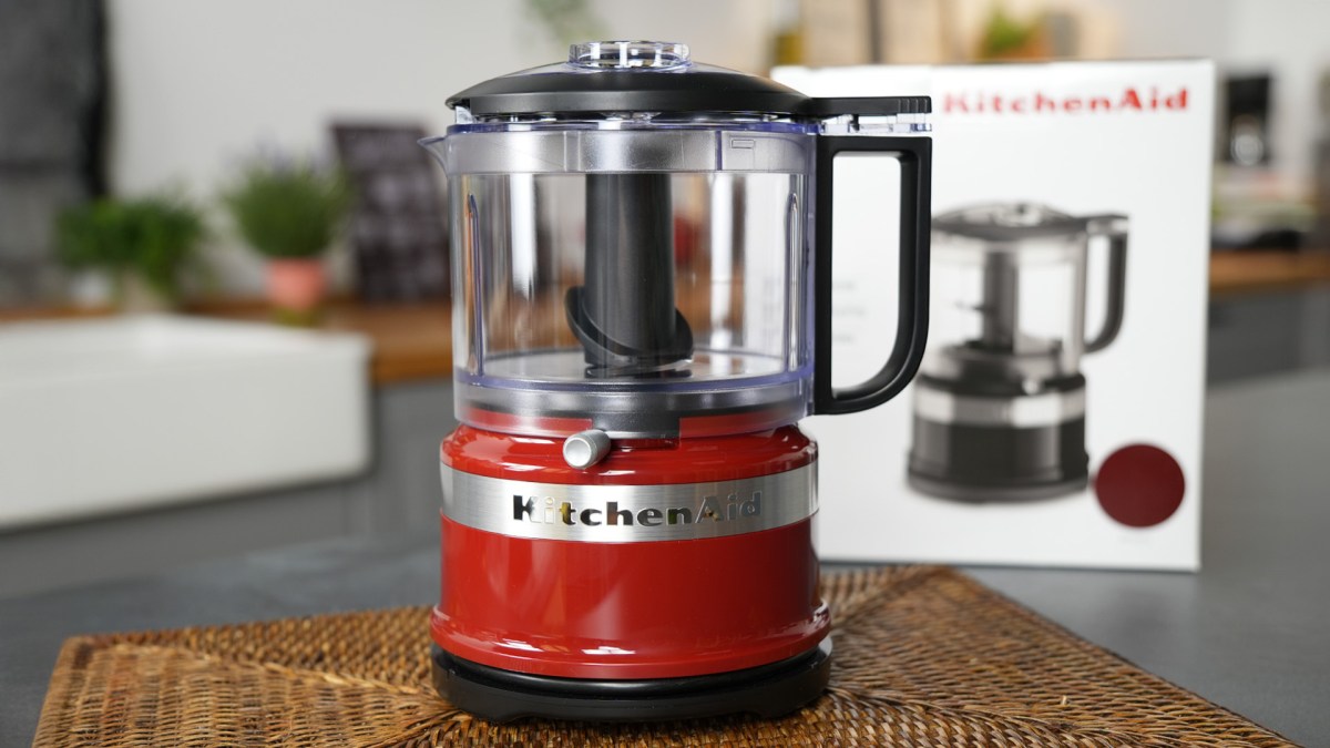 Ein Mini-Foodprocessor von KitchenAid, der auf einer Arbeitsfläche in einer Küche steht. Im Hintergrund kann man den Verpackungskarton erkennen.