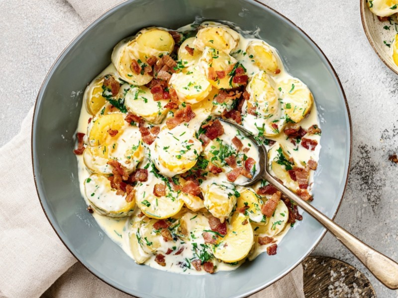 Eine Schüssel Petersilienkartoffeln mit Schinken in der Draufsicht.