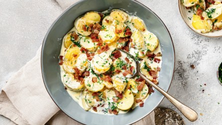 Eine Schüssel Petersilienkartoffeln mit Schinken in der Draufsicht.