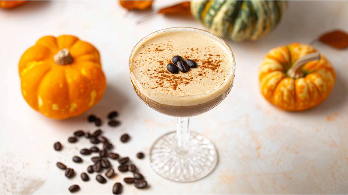 Glas mit Pumpkin Spice Espresso Martini, Zierkürbisse daneben