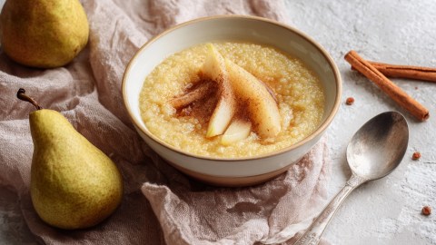 Eine Schüssel süße Hirsesuppe mit Birnen und Zimt.
