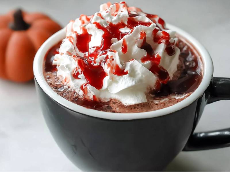 Tasse Heiße Vampir-Schokolade, Kürbis im Hintergrund