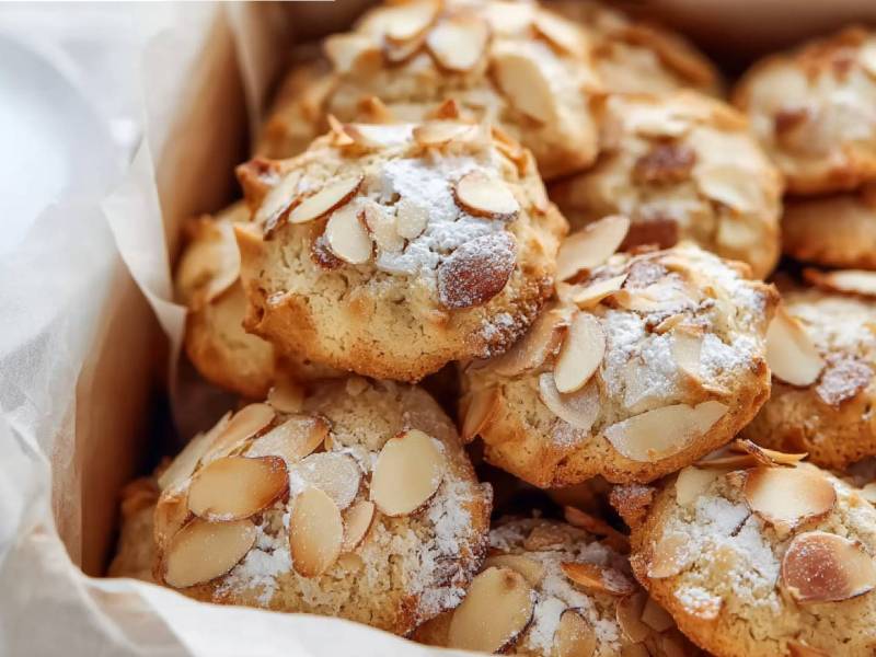 Eine Dose mit Bienenstich-Keksen und einer Tasse Kaffee daneben