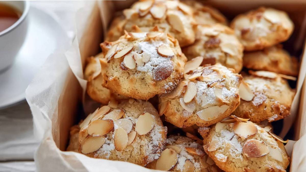 Eine Dose mit Bienenstich-Keksen und einer Tasse Kaffee daneben