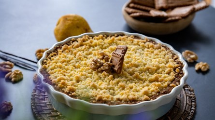 Eine Tarteform mit Birnen-Crumble mit Ziegenkäse garniert mit Walnüssen und Karamell-Keksen.
