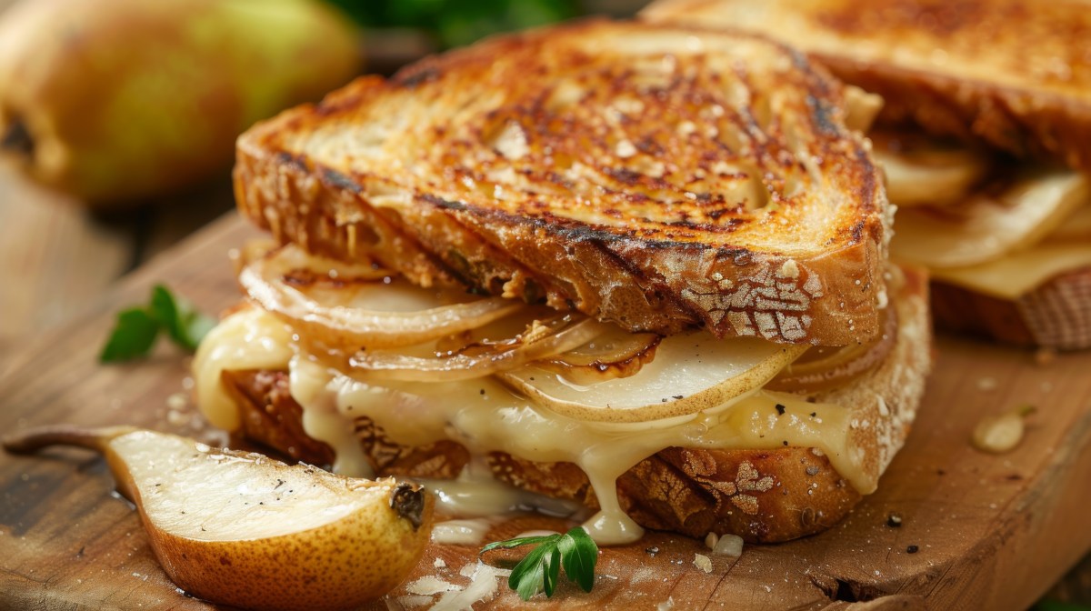 Ein grilled Cheese Sandwich mit Birne auf einem Holzbrett