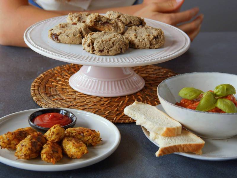 Teller mit Kaffeesatz-Cookies auf einem Tisch, andere Gerichte daneben