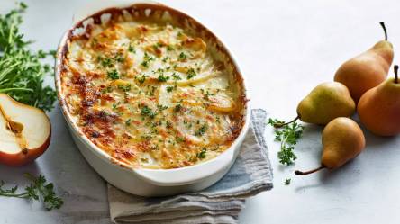 Auflaufform mit Kartoffel-Birnen-Gratin, Birnen daneben