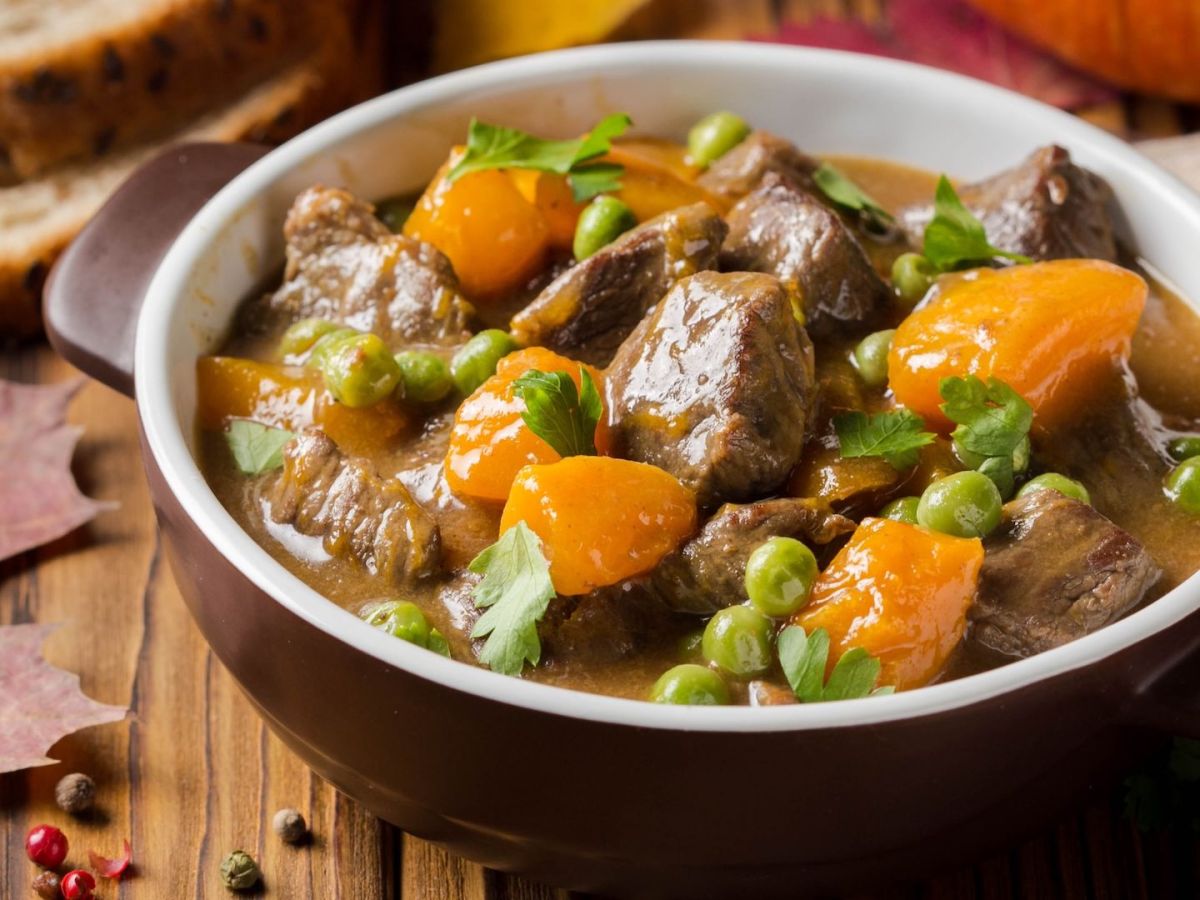 Eine Schale Kürbis-Rinder-Gulasch mit Erbsen.