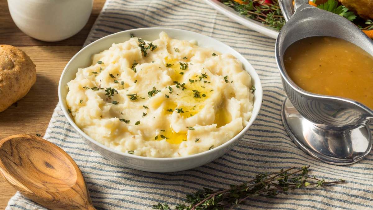 Eine Schale Miso-Kartoffelpüree, garniert mit geschmolzener Butter und Thymian.